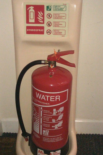 HTC Legend phone on top of a red water fire extinguisher.