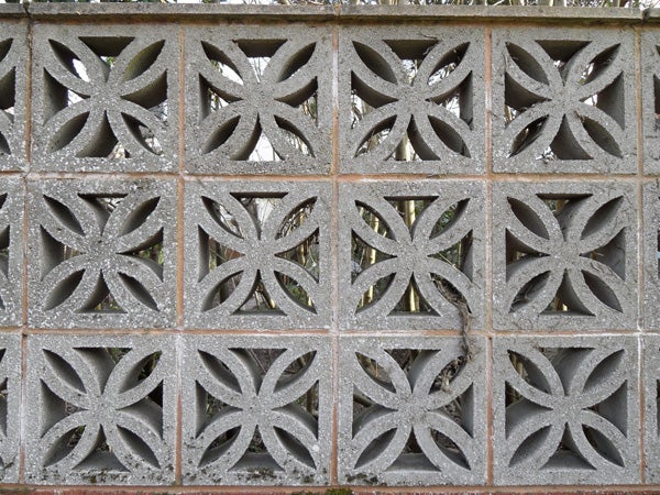 Decorative concrete block wall with a repeated pattern.