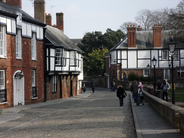 Photo captured by Samsung WB1000 of a cobblestone street with people and Tudor-style houses.