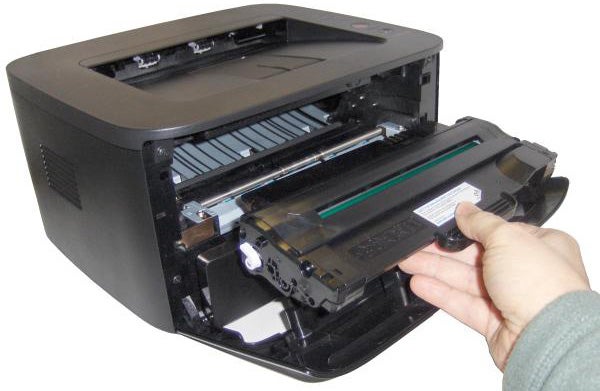 Person replacing toner cartridge in Dell 1130 laser printer.