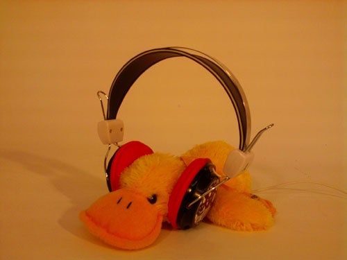 Samsung Diva S7070 phone with headphones on a plush toy.