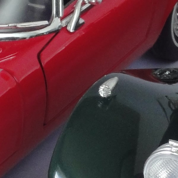 Close-up photo of vintage red and green cars