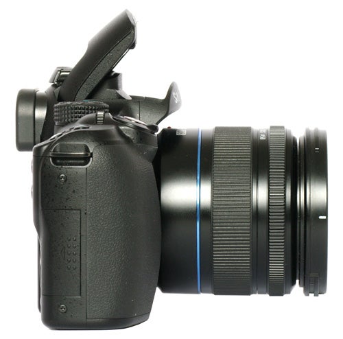 Samsung NX10 camera with lens and flash raised.