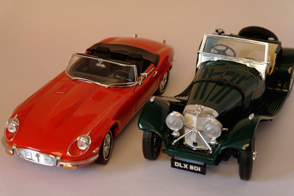 Close-up of two model cars, one red and one green.