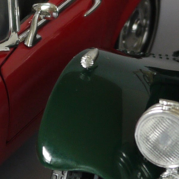 Close-up of a red and green toy car's front end.