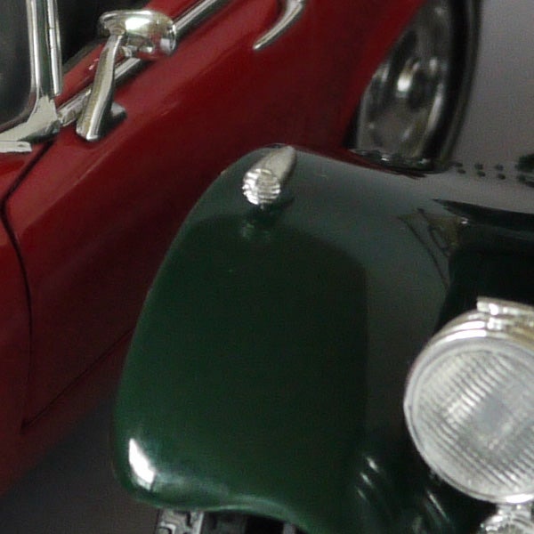 Close-up of a red and green vintage toy car.