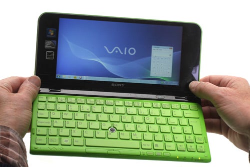 Hands holding a green Sony VAIO P Series mini laptop.