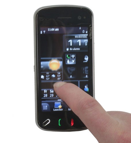 Hand interacting with SPB MobileShell on a Symbian smartphone.