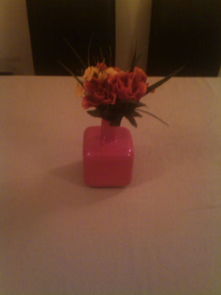 Flowers in a pink vase on a table.