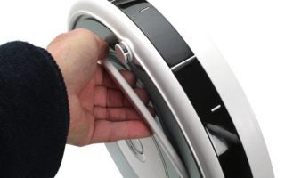 Hand carrying iRobot Roomba 520 by built-in handle.