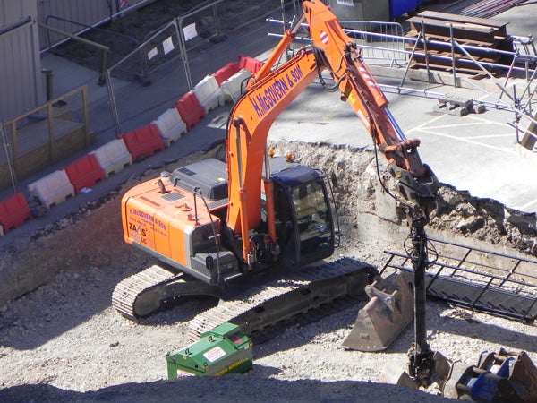 Orange excavator on construction site with debris