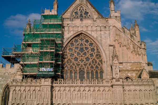Historic cathedral undergoing renovation under blue sky.