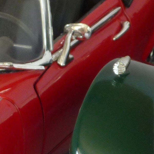 Close-up of classic red car details taken with camera.