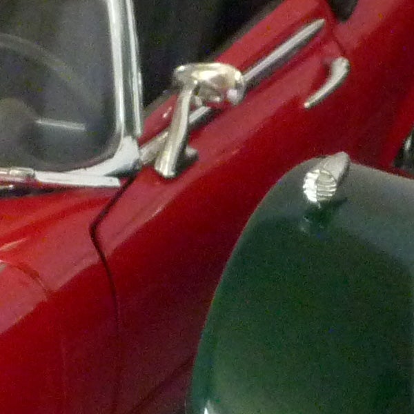 Photo of a red vintage car with chrome details.