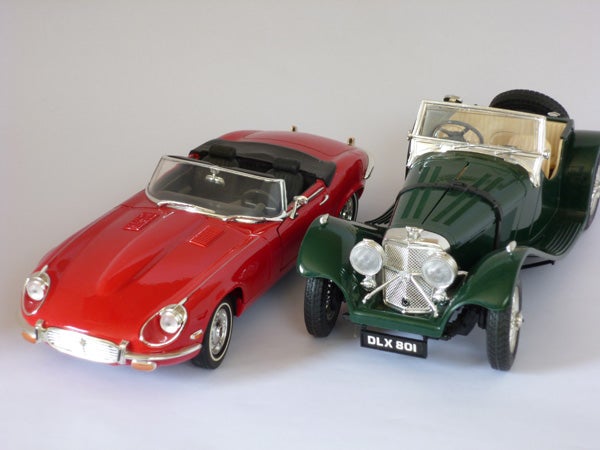Red and green vintage model cars on a white background.