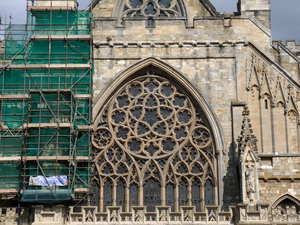 Detailed cathedral facade with scaffolding on the left side.
