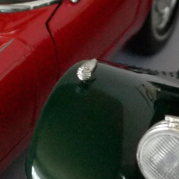 Close-up of vintage car hood and headlights.