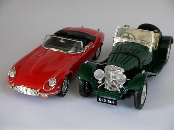 Red and green vintage model cars on white background.
