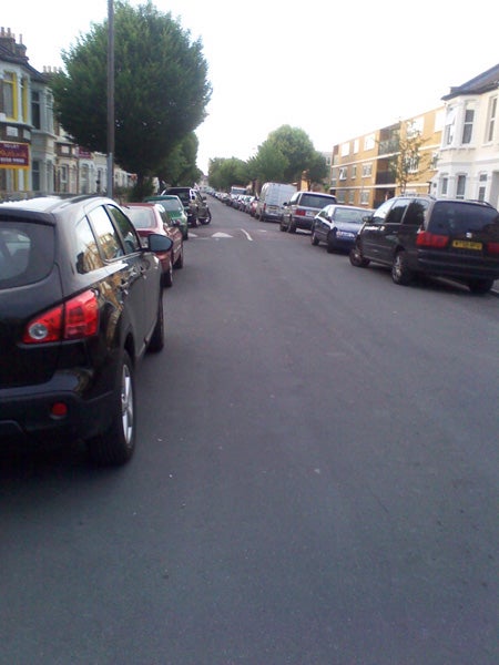 Photo taken with Huawei U7510 showing a street lined with parked cars.