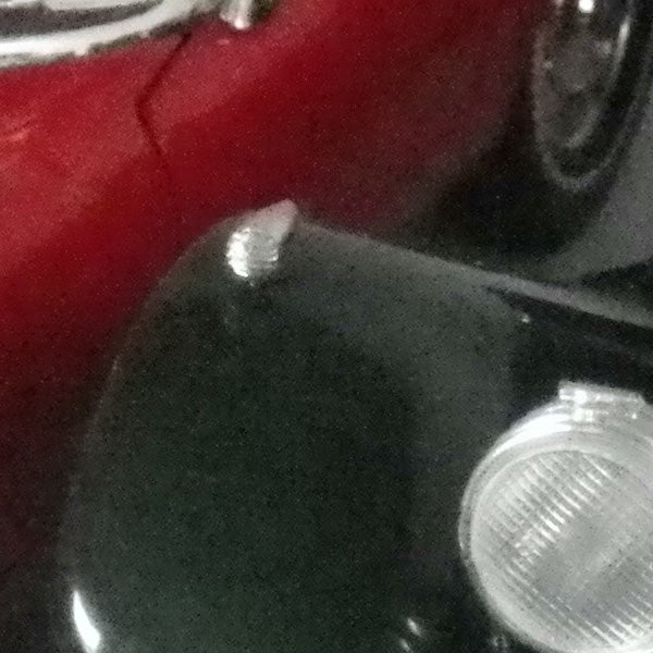 Partial view of a car's headlamp and hood.