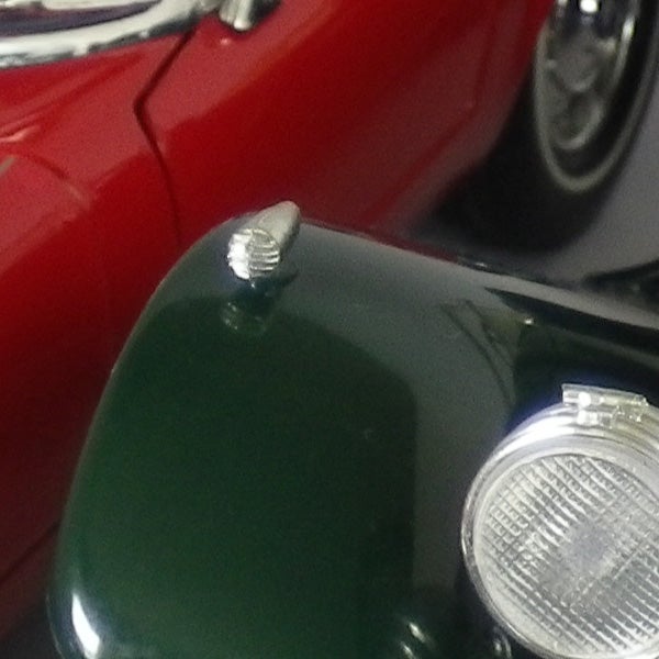 Close-up of a classic car hood and headlight.