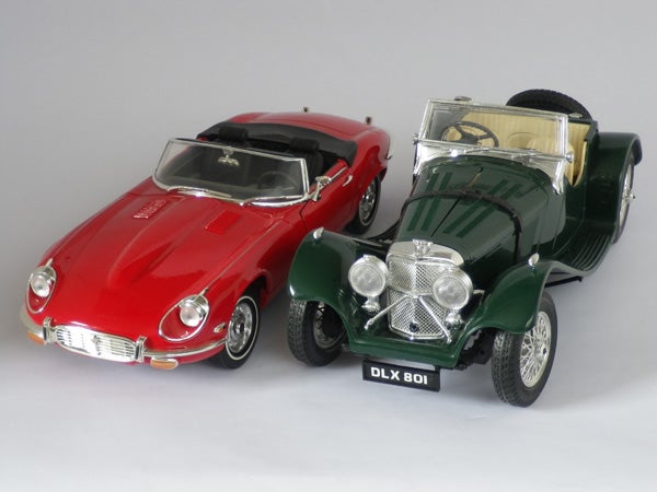 Two vintage model cars on a gray background.