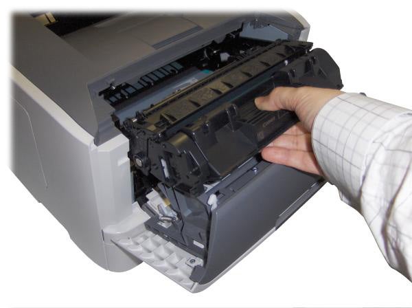 Person replacing toner cartridge in Canon LBP6650dn printer.