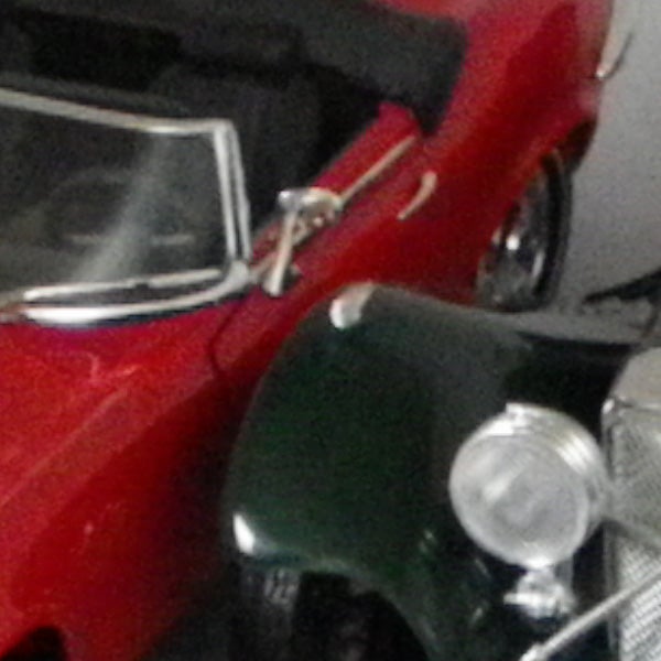 Close-up of toy cars with blurring indicating camera shake.