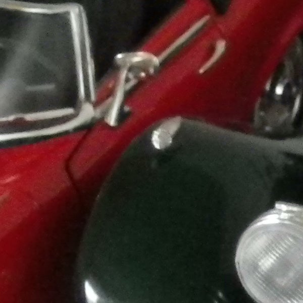 Red classic car model in close-up view.
