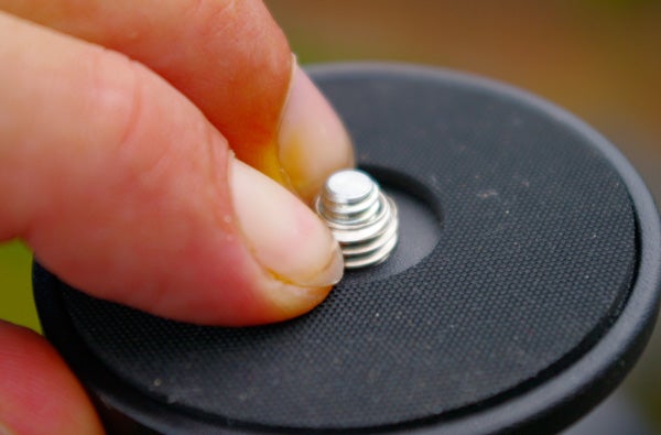 Close-up of Manfrotto tripod head quick release plate with screw.