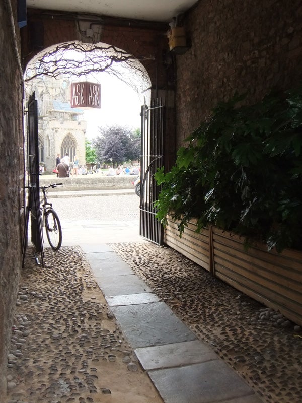 Photograph taken with Fujifilm FinePix Z700 showing a cobblestone passageway leading to a square.