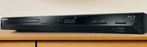 Toshiba BDX2100 Blu-ray player on wooden surface.