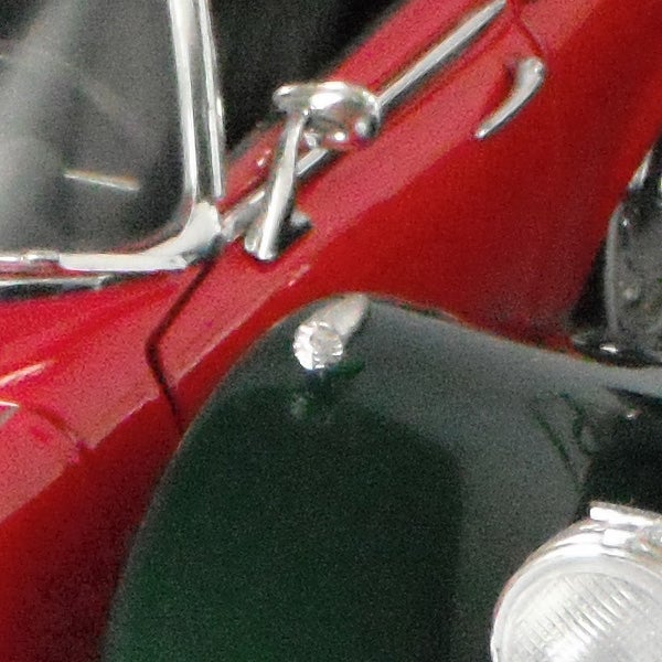 Close-up of a red vintage car's side detail.
