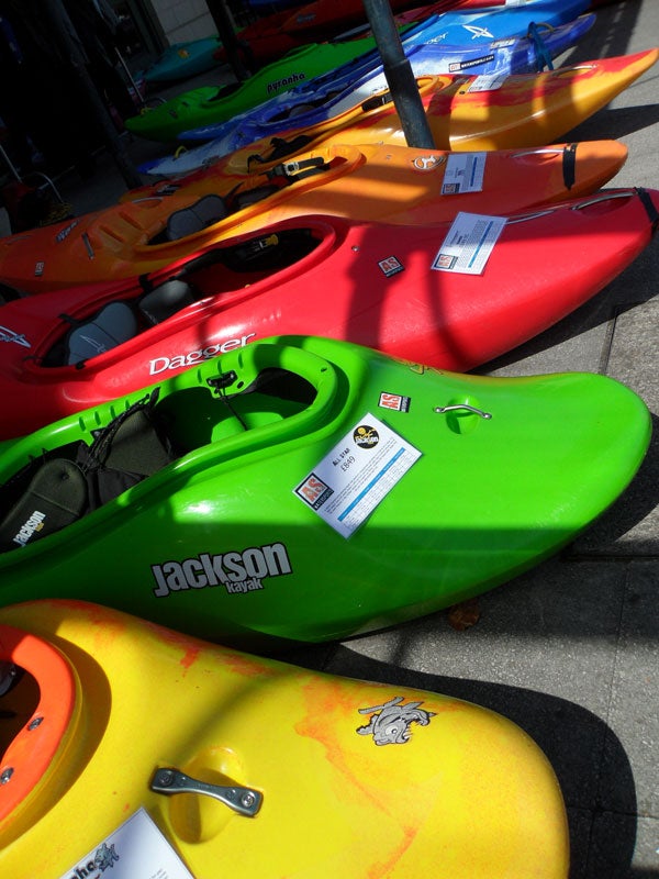 Colorful kayaks lined up for sale outdoors