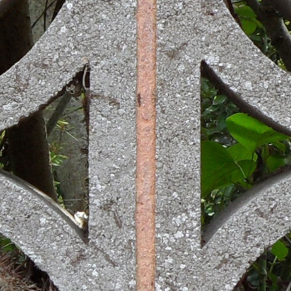 Decorative geometric pattern on concrete with rusted iron stripe.