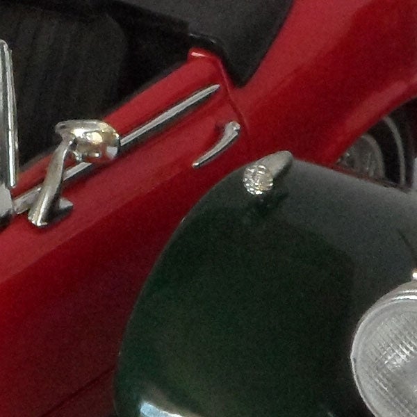 Close-up of a vintage red car's side mirror and details.