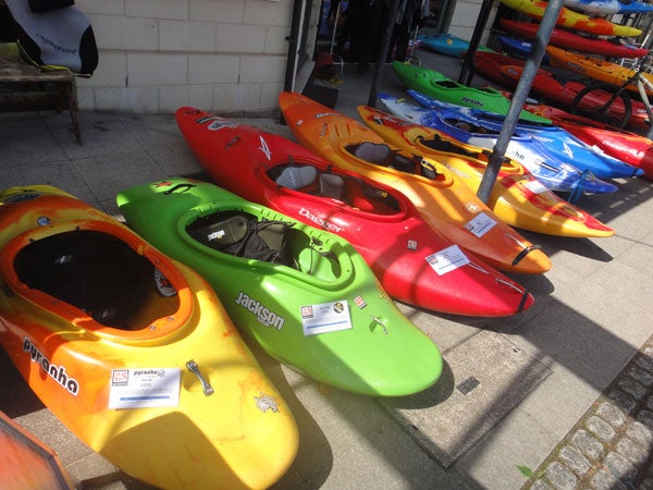 Row of colorful kayaks for sale outside a store