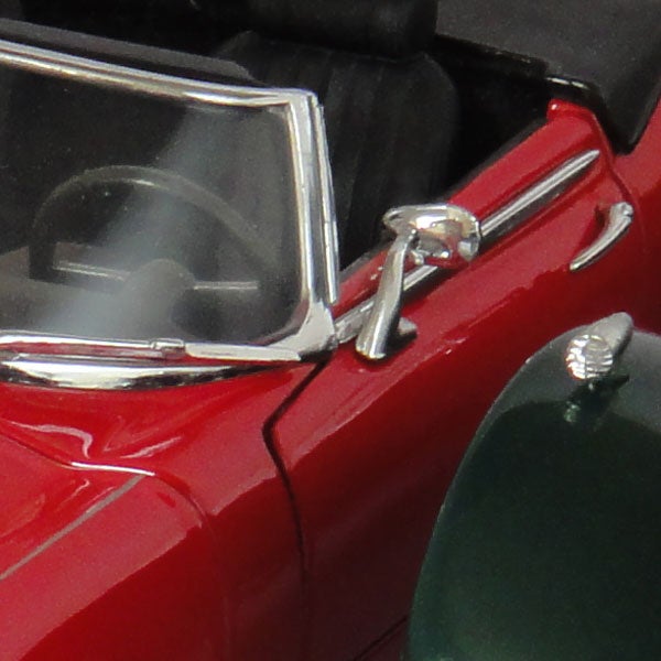 Close-up of red toy car's door and side mirror.
