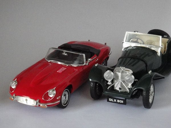 Two model cars photographed with a gray background