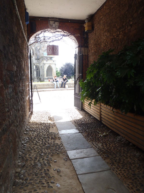 Olympus mju-Tough 6020 camera photo of a cobblestone pathway leading outdoors.