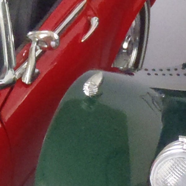 Close-up of a red vintage car's shiny details.