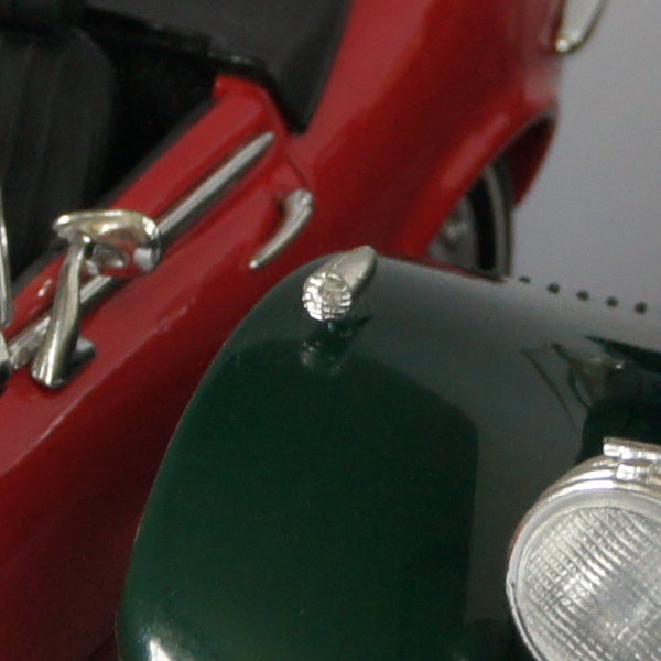 Close-up of a red vintage car model side mirror.