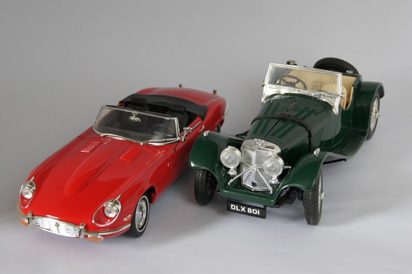 Red and green vintage toy cars on a gray background