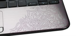 Close-up of Dell Inspiron M101z laptop's keyboard and patterned palm rest.