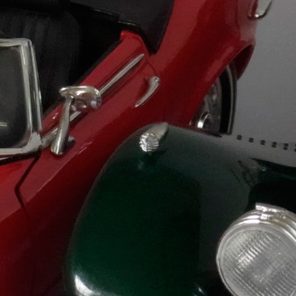 Close-up photo of a red and green vintage car model.