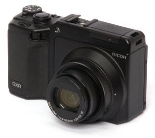 Ricoh GXR camera with lens attached on white background.