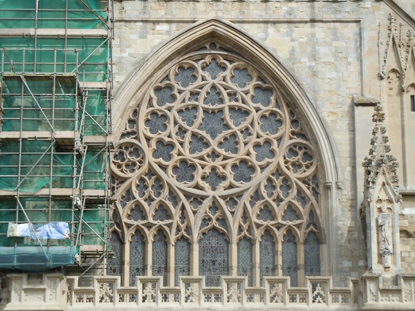 Detailed photo of gothic cathedral window with scaffolding on side