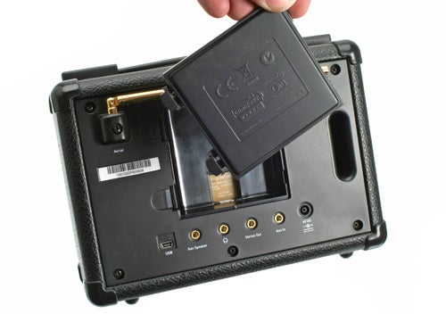 Hand holding Pure Evoke-1S Marshall radio showing the battery compartment.