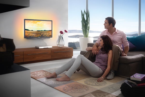 Couple watching Philips TV in a modern living room.