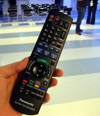 Hand holding a Panasonic Blu-ray recorder remote control.